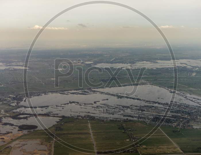 Netherlands, Hague, Schiphol, A Body Of Water With A Mountain In The Background