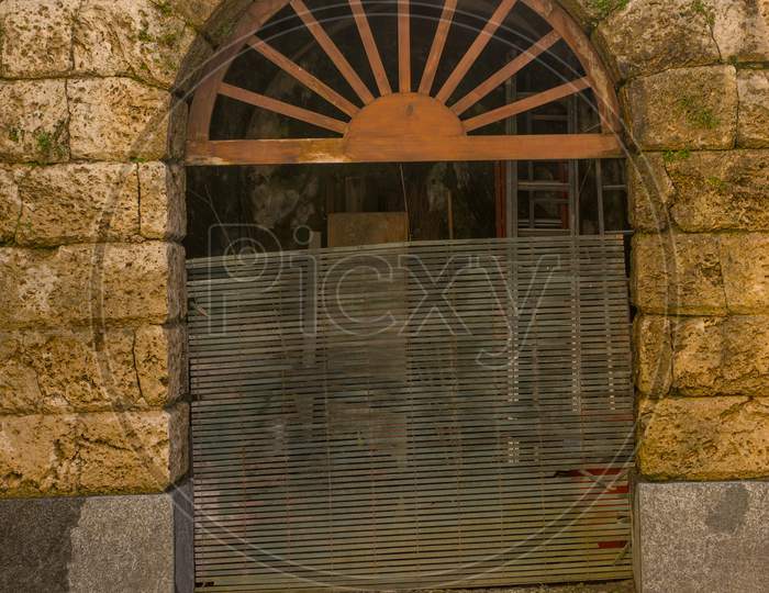 Italy, Bellagio, Lake Como, A Rustic Gate In Front Of A Brick Building