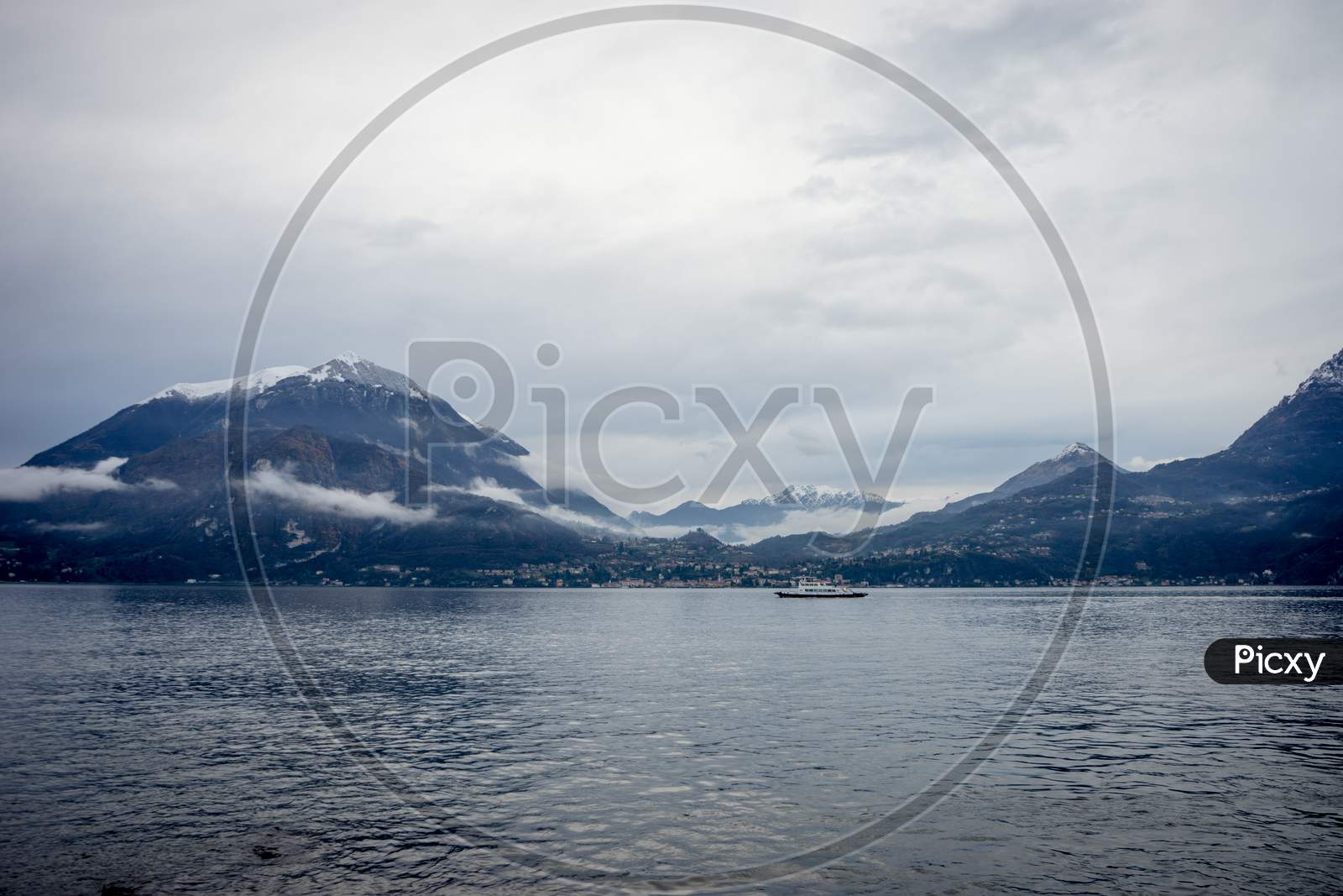 Italy, Varenna, Lake Como, Boat In A Serene Scene With Snow Cap Mountain