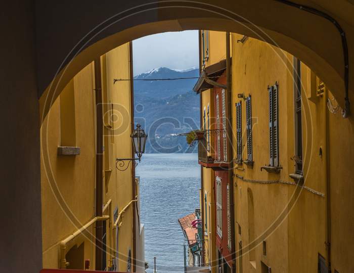 Italy, Varenna, Lake Como, A View Of A Lake Under An Arch