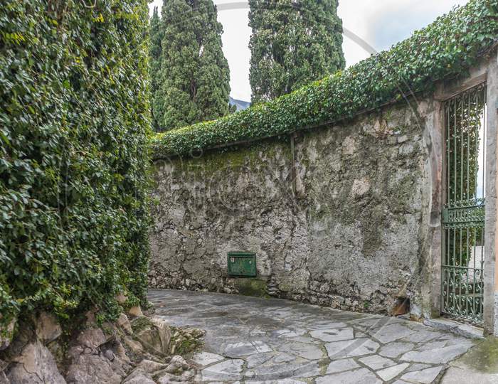 Italy, Varenna, Lake Como, A Stone Building That Has Trees Around It