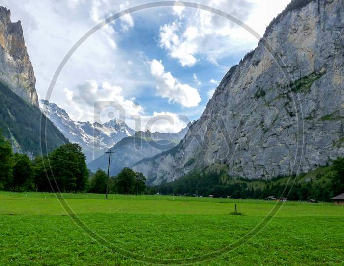 Switzerland, Lauterbrunnen, Scenic View Of Field And Mountains Against Sky