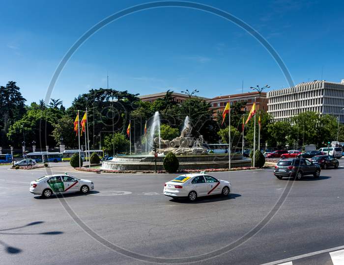 Madrid, Spain- June 17, 2017 : Cars Pass In Front Of The Plaza De Cibeles In Madris, Spain On A Hot Summer Day.