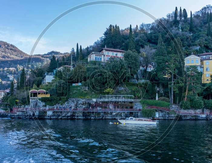 Italy, Bellagio, Lake Como, Lake Como, A Small Boat In A Body Of Water With Lake Como In The Background