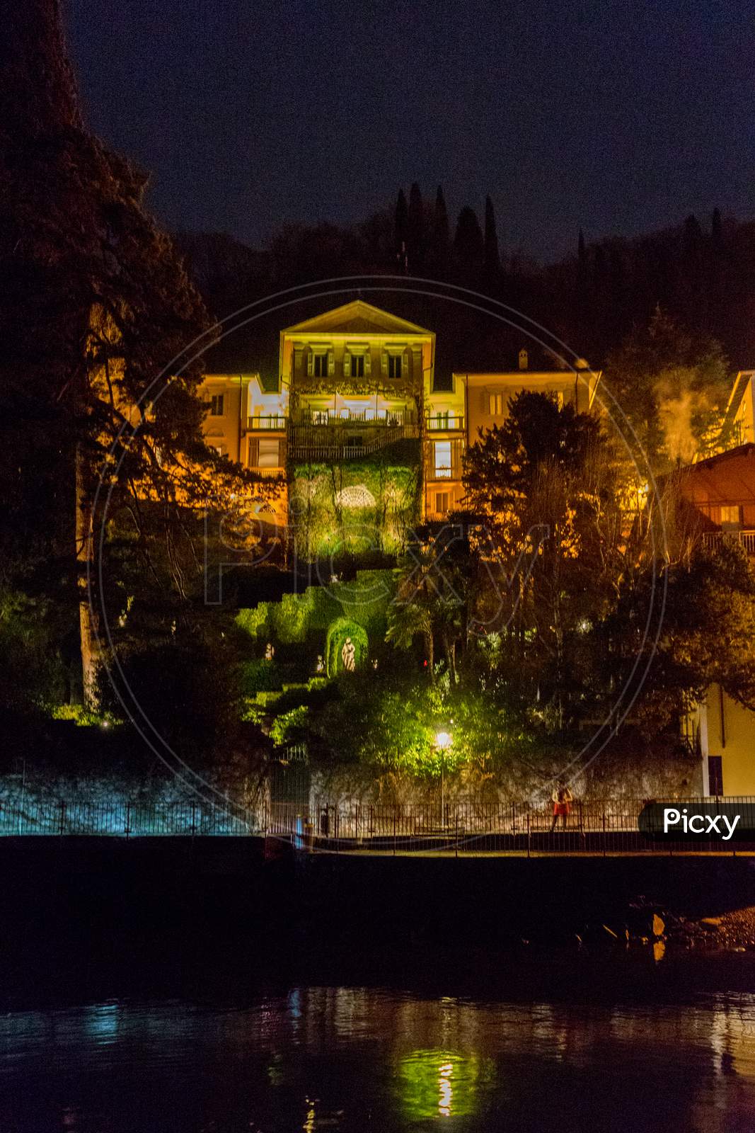 Italy, Varenna, Lake Como, Illuminated Buildings By Lake At Night