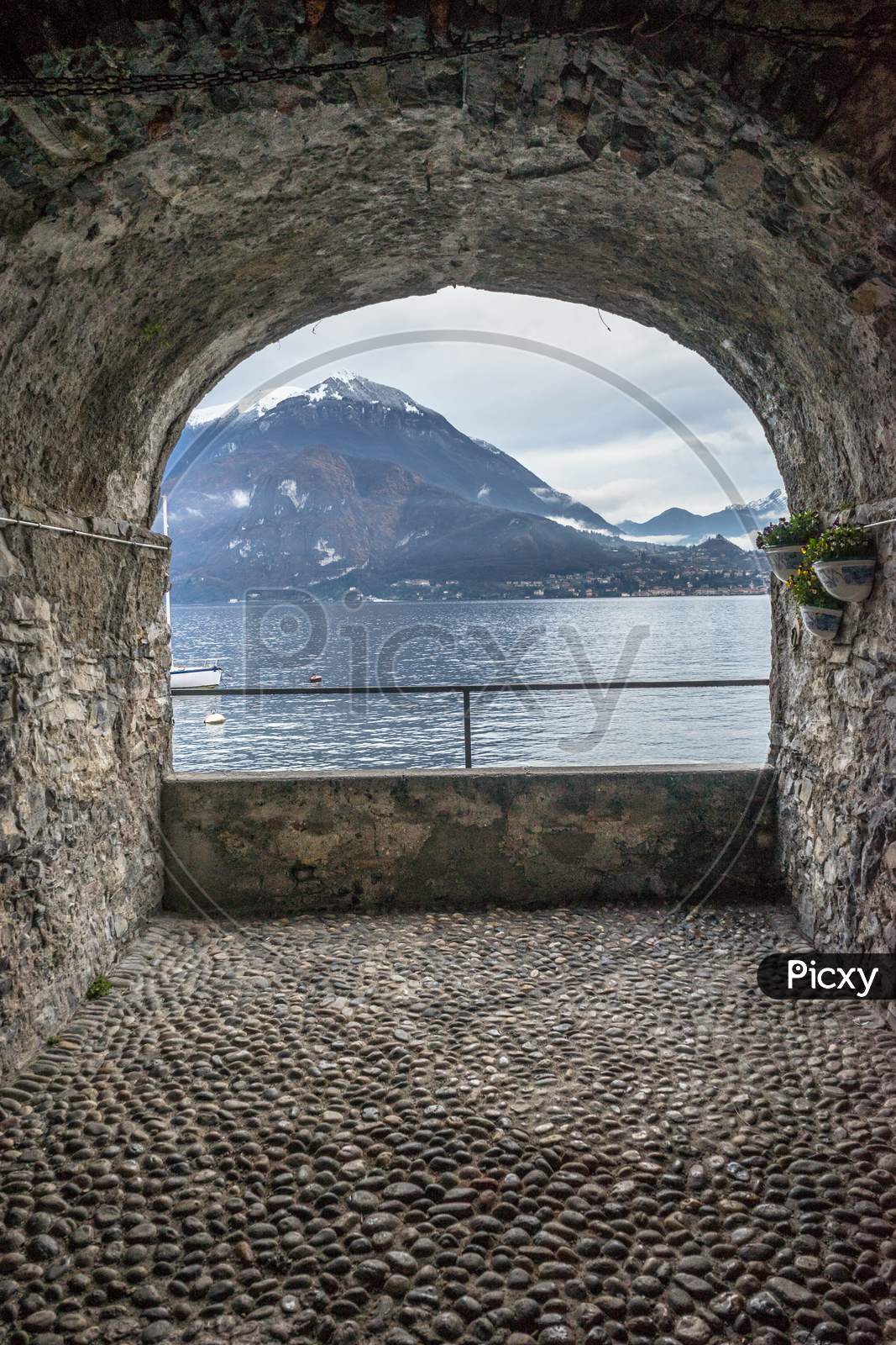 Italy, Varenna, Lake Como, Scenic View Of Sea Seen Through Arch Window
