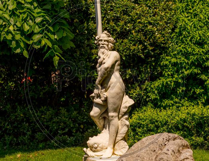 Netherlands, Giethoorn, A White Statue In A Garden With A Clamp Shell