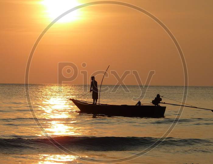 Indian Beach Fishing Man on Boat at sunset on sea