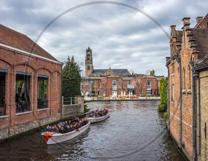 Brugge, Belgium - April 17 :  Tourists Take A Boat Ride On A Canal In Front Of St. Salvator'S Cathedral In Bruges, Belgium, Europe