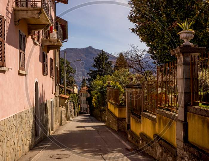 Italy, Menaggio, Lake Como, A Narrow Street In Front Of A Building