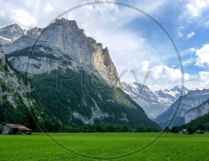 Switzerland, Lauterbrunnen, Scenic View Of Green Landscape And Mountains Against Sky