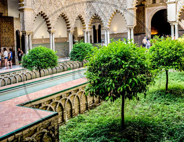 Seville, Spain- June 18, 2017 : People Walk In The Courtyard Of The Alcazar Palace In Seville, Spain June 2017.
