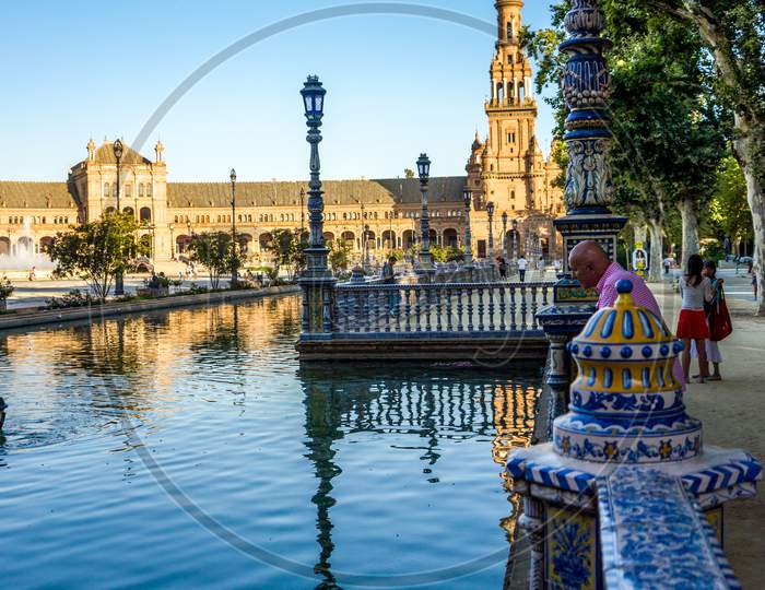 Seville, Spain- June 18, 2017 : People Gather Next To The Water Pond At The Plaza De Espana In Seville, Spain June 2017 On A Hot Summer Day.