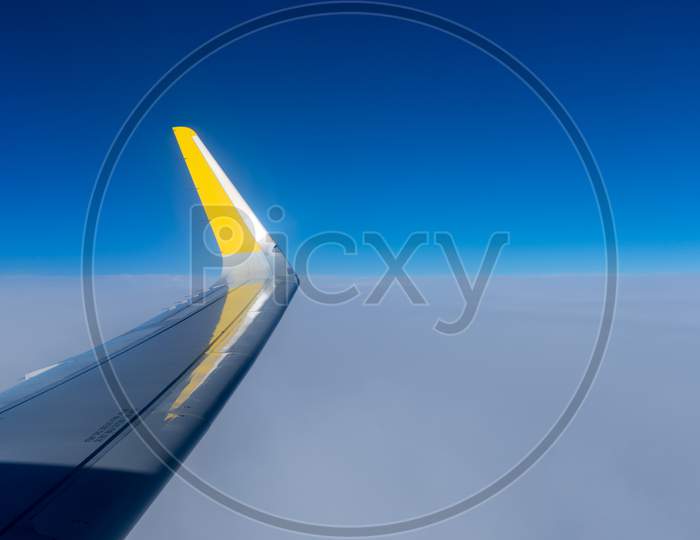 Netherlands, Hague, Schiphol, A Blue And Yellow Airplane Is Flying In The Sky