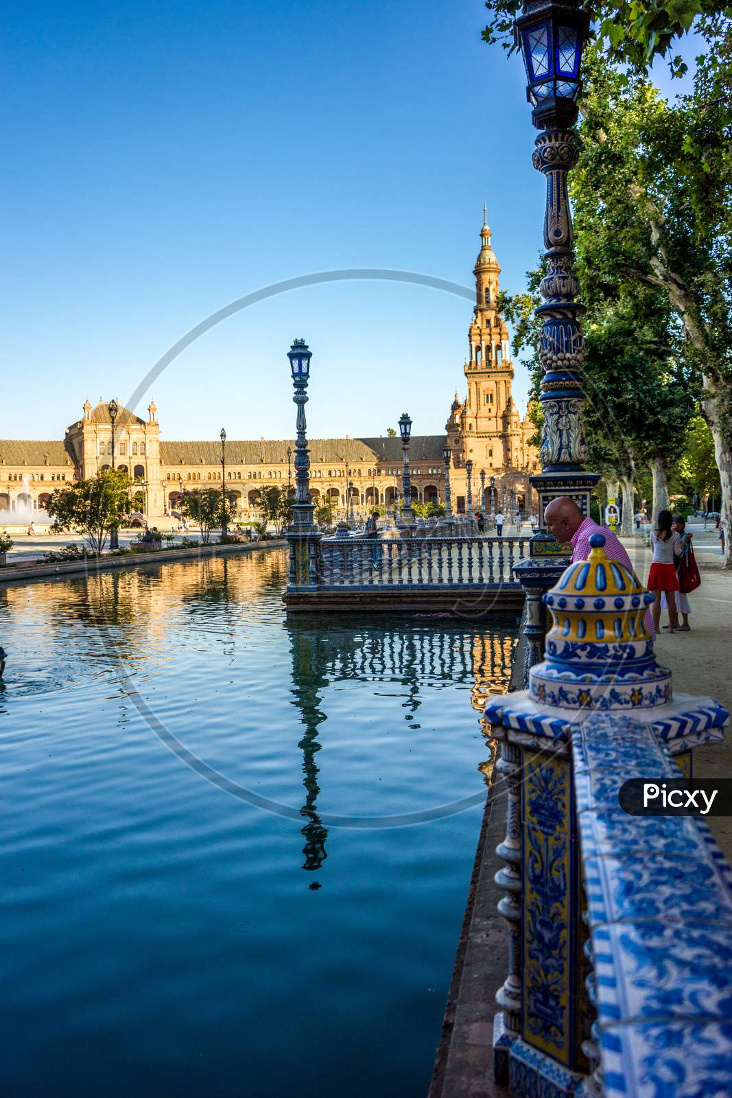 Seville, Spain- June 18, 2017 : People Gather Next To The Water Pond At The Plaza De Espana In Seville, Spain June 2017 On A Hot Summer Day.