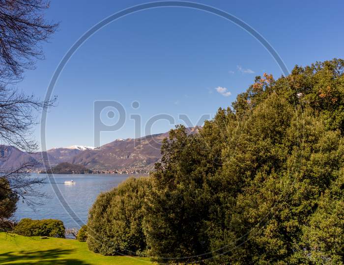 Italy, Bellagio, Lake Como, A Large Body Of Water Surrounded By Trees