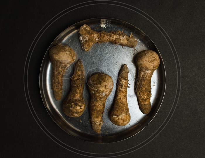 dirty plucked mushroom high in calcium placed in a plate on a black textured background concept