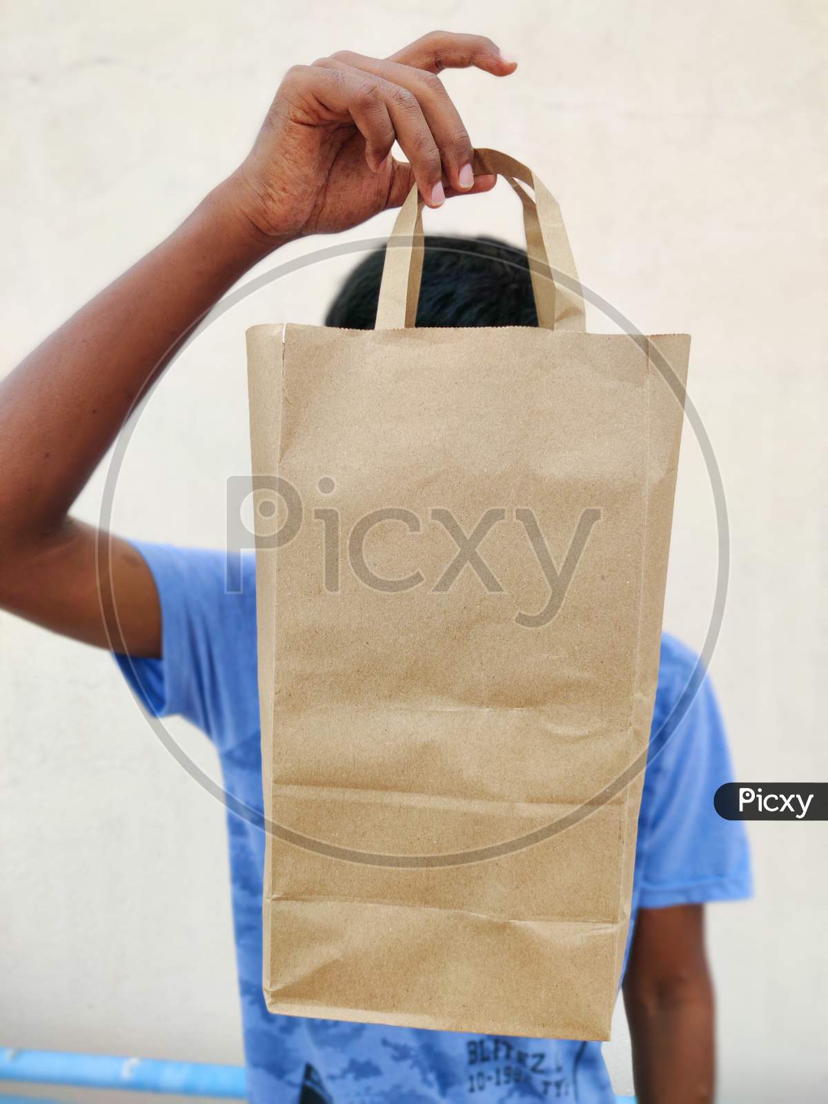South Indian Young Man Covering His Face With Shopping Bag. Shopping Concept. White Background