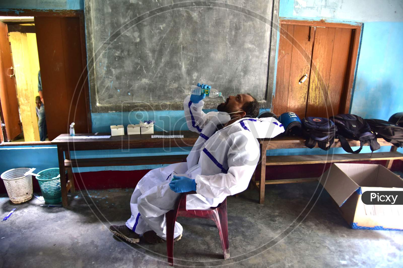 A health worker in personal protective equipment (PPE) take a rest  while waiting for people to collect samples to conduct tests for the coronavirus disease (COVID-19), amid the spread of the disease in Nagaon district, in the northeastern state of Assam on sept 30,2020.