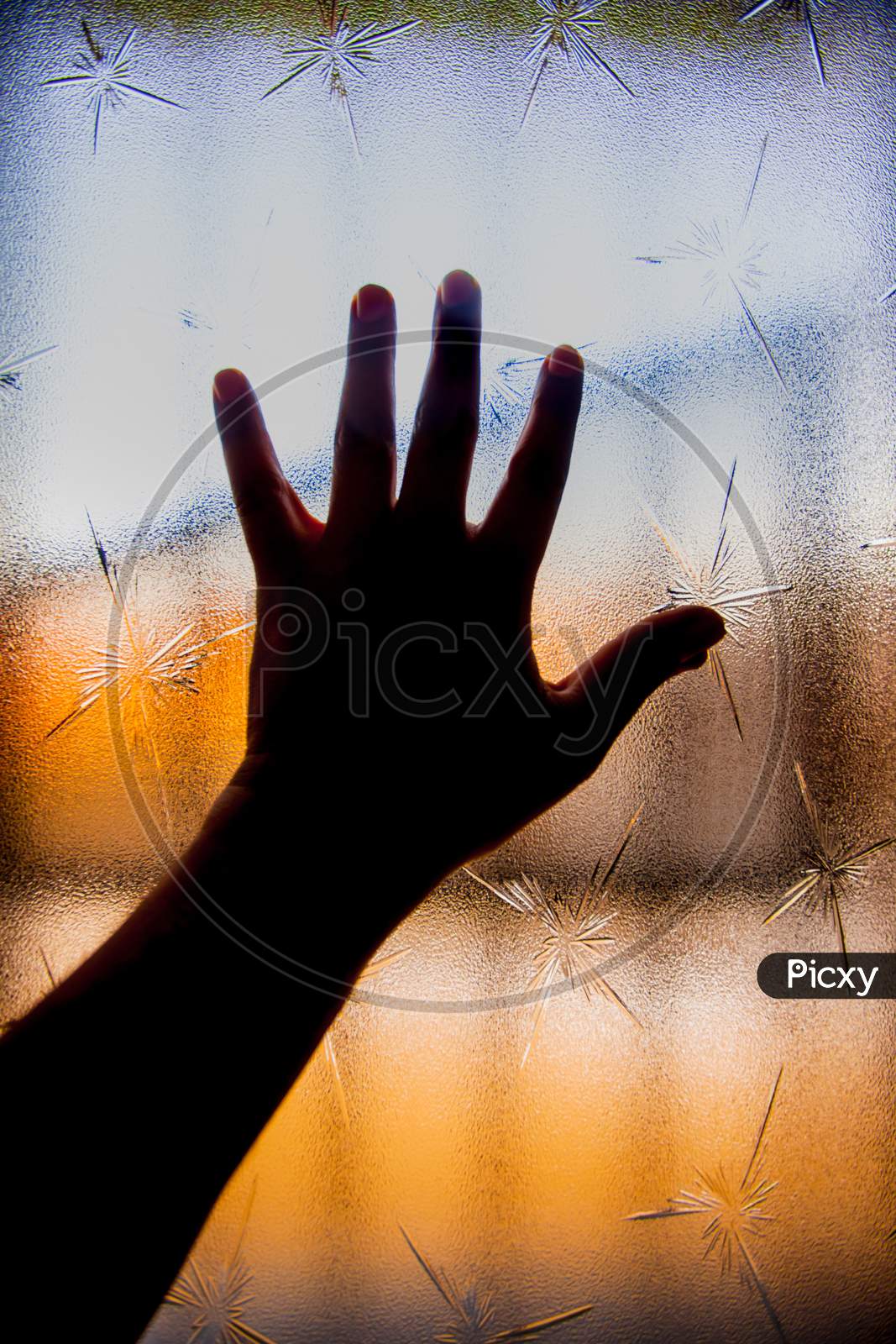 Silhouette Of Human Hand Against Window Glass