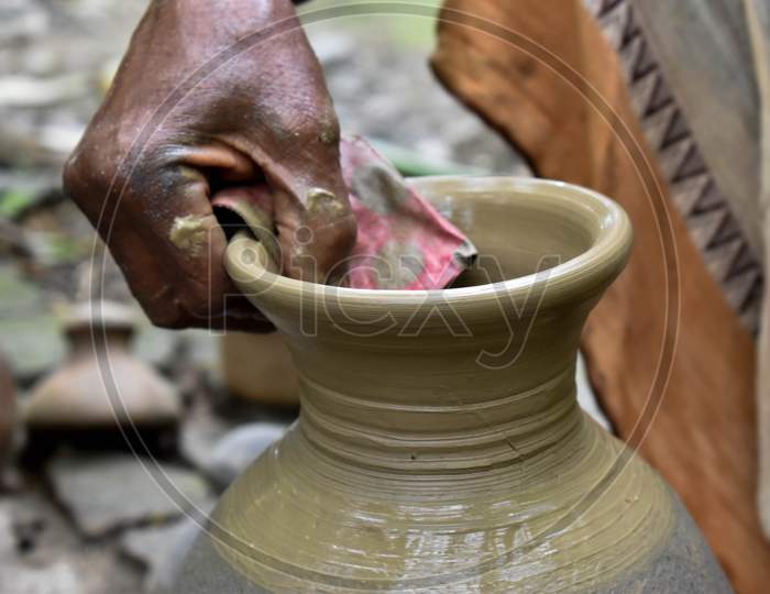 A potter is making beautiful clay pots using his potter's wheel, it is his job. If you want to make a clay pot, first you have to get good soil, then you can make a clay pot with the help of hands and wheels.
