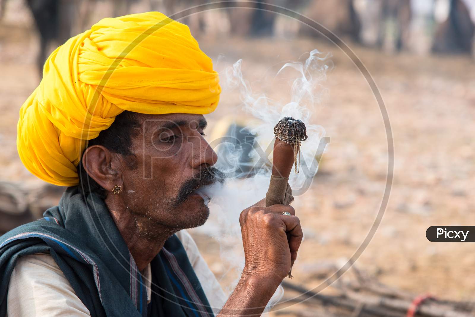 A camel herder smoking