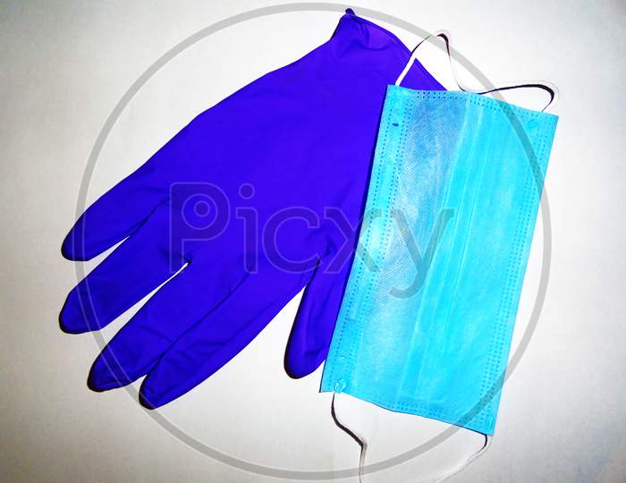 Blue color disposable surgical mask and glove on white background