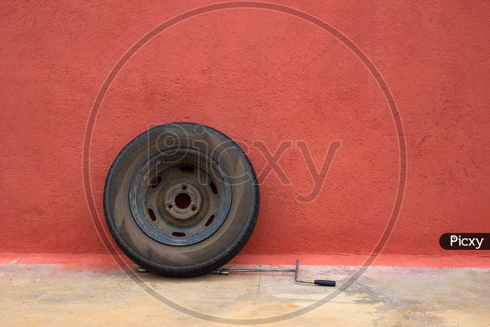 Old car Tyre with wheels with colorful red wall background