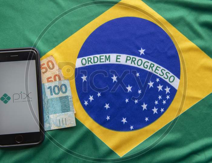 Florianopolis, Brazil. 28/09/2020: Top View Of Pix Logo On Smartphone Screens On Brazilian Flag And Banknotes. Pix Is New Brazilian Electronic Payment System. Brazilian Central Bank. Copy Space.