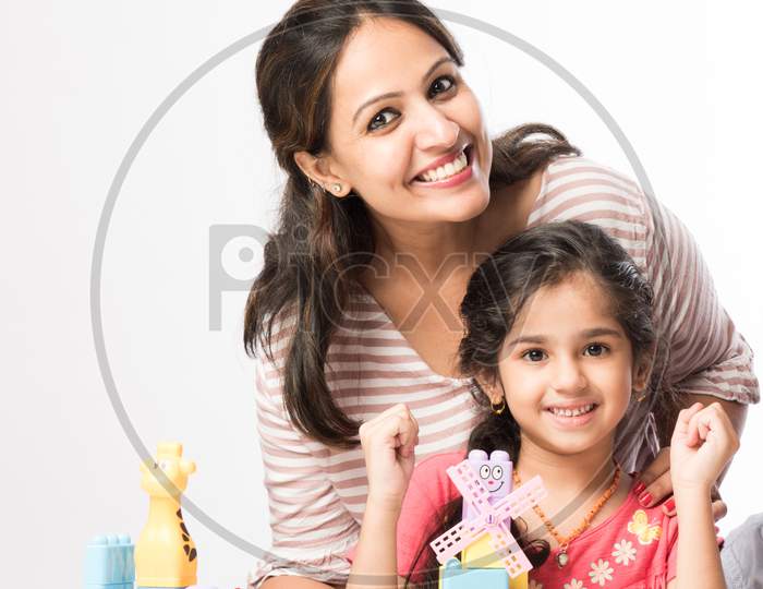 Cute Little Indian Kids Playing Colourful Block Toys With Parents At Home