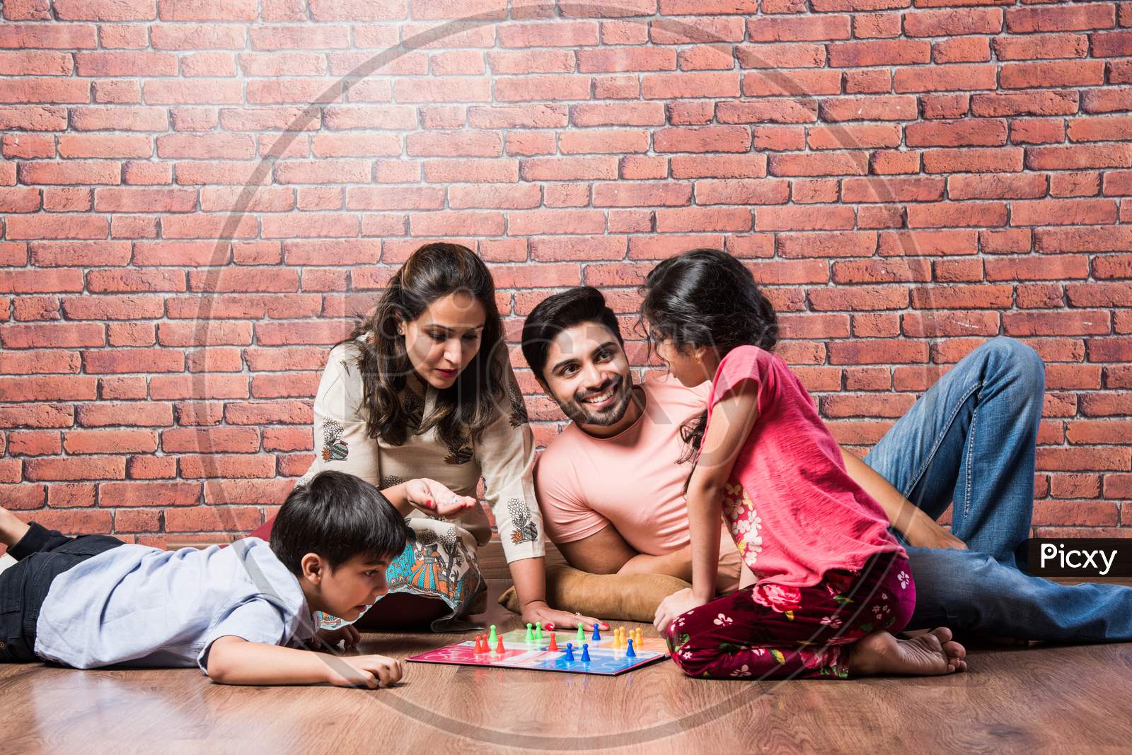 Image of Indian Happy Family Playing Board Games Like Chess, Ludo Or Snack  And Ladder At Home In Quarantine-NR052209-Picxy