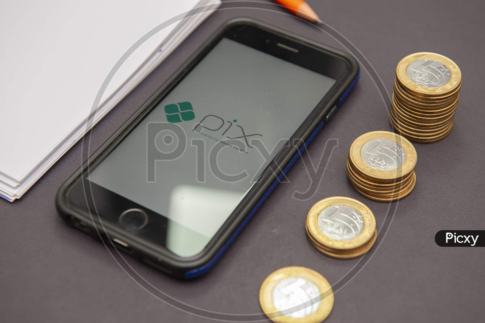 Florianopolis, Brazil. 28/09/2020: Top View Of Pix Logo On Smartphone Screen Next To Growing Piles Of Coins. Pix Is ​​A New And Faster Brazilian Money Transfer System - Central Bank. Selective Focus.