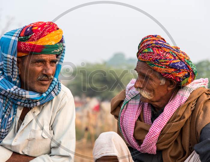 Two camel herders engaged in a conversation