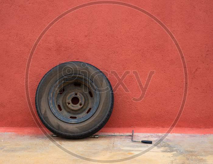 Old car Tyre with wheels with colorful red wall background