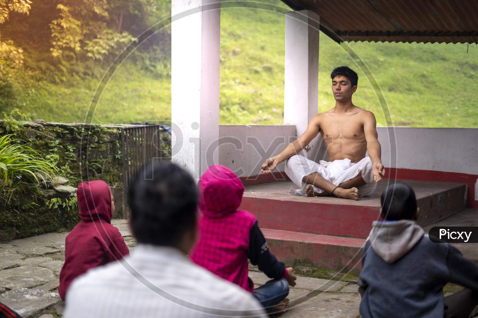 Almora, India - September 02, 2020: Young Man Wearing A White Dhoti Taking Yoga Classes Of Young Kids And Older Men