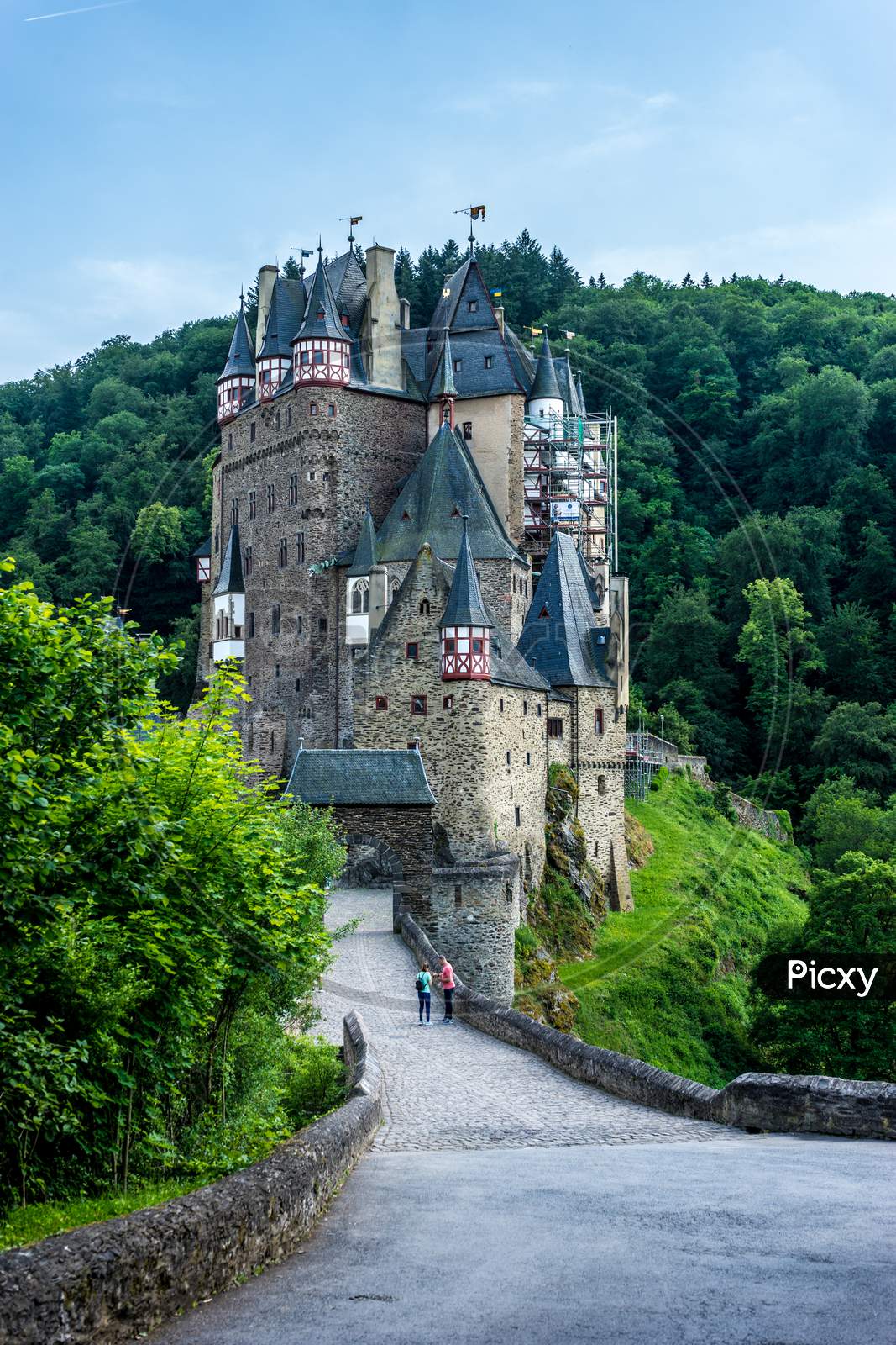 Germany, Burg Eltz Castle, Eltz Castle, A Stone Castle Next To A Forest With Eltz Castle In The Background