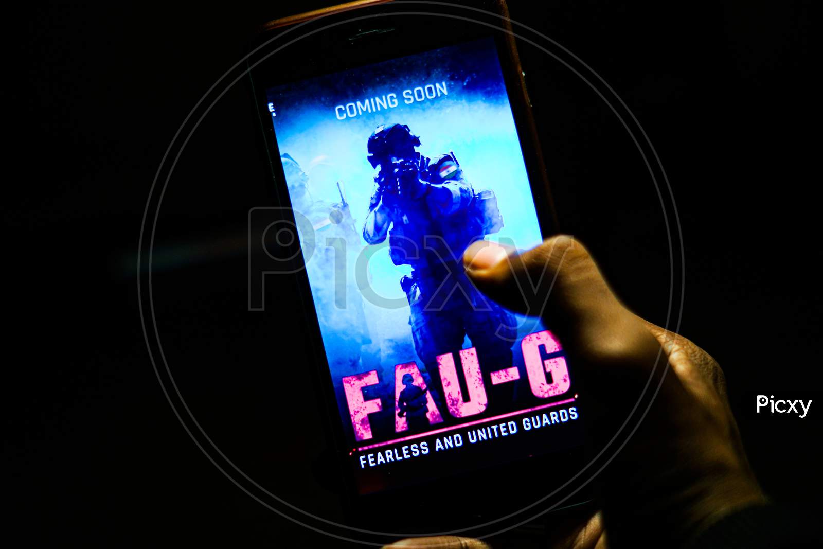 Close up shot of a Person Holding Smartphone with FAUG Game on Screen