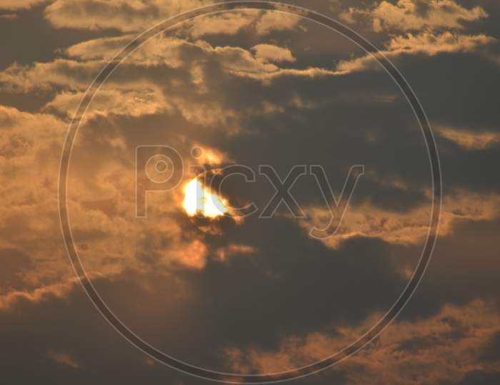 Sun hidden behind the clouds with orange sky photography