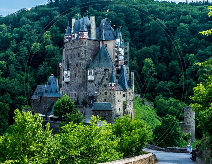 Germany, Burg Eltz Castle, A Small Clock Tower In A Garden