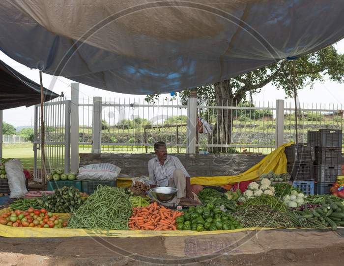 A Vegetable Farmer seen relaxing with his Produce in Srirangapatna /Karnataka/India.