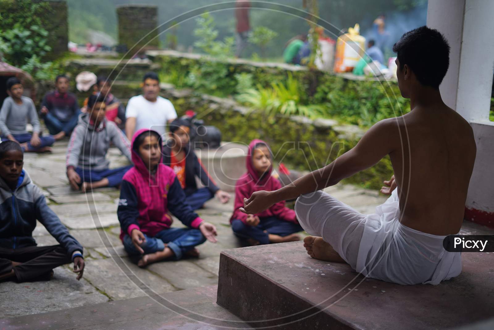 Almora, India - September 02, 2020: Young Man Wearing A White Dhoti Taking Yoga Classes Of Young Kids And Older Men