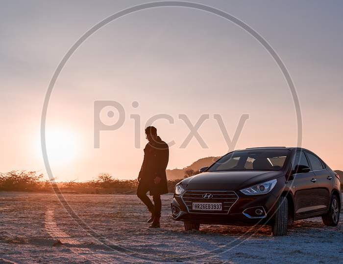 model with cars in sunset posing in the desert