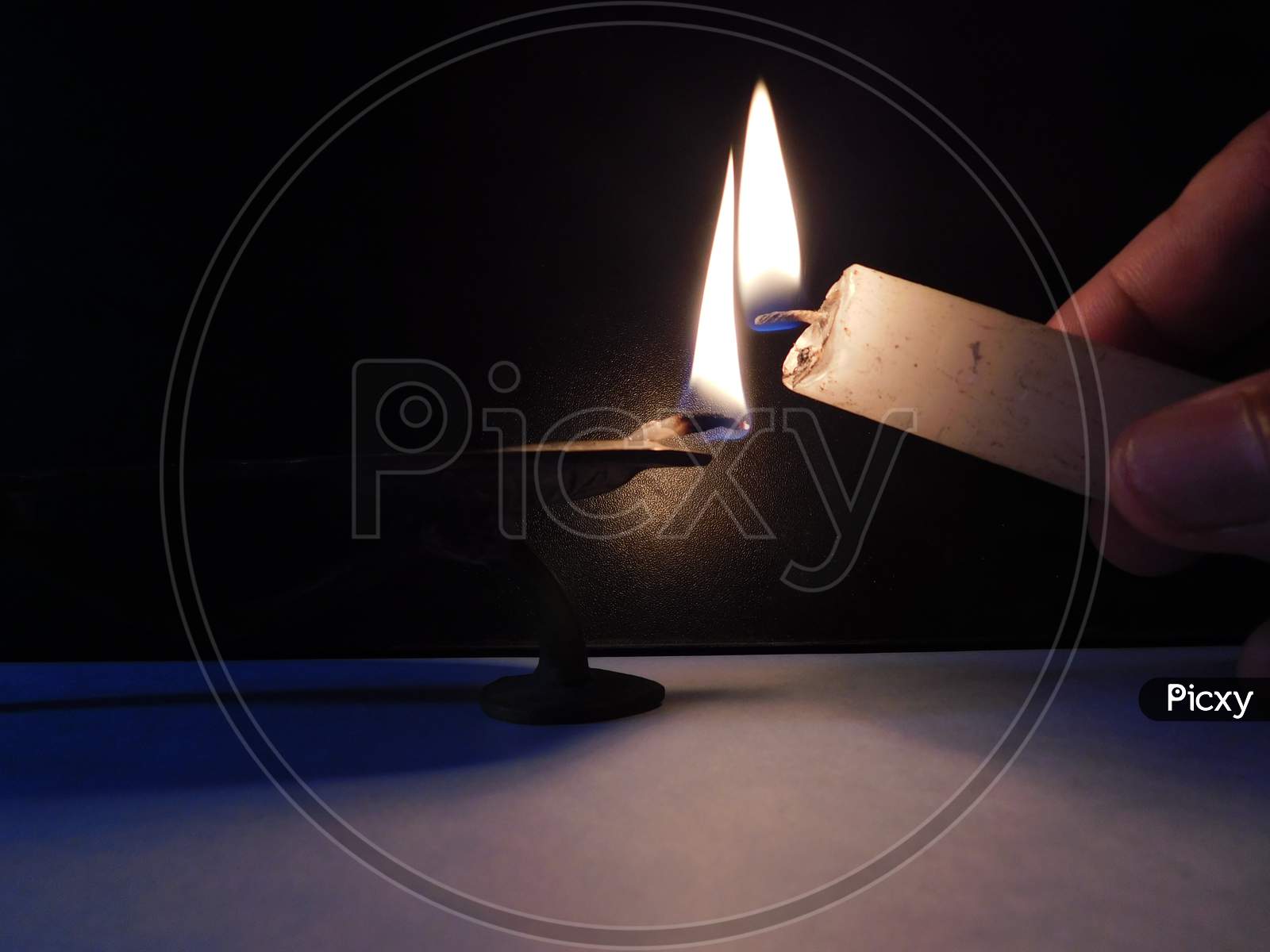 Light from the lamp and light from the candle on the dark background