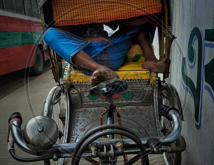 A happy man sleeping in the rikshaw.