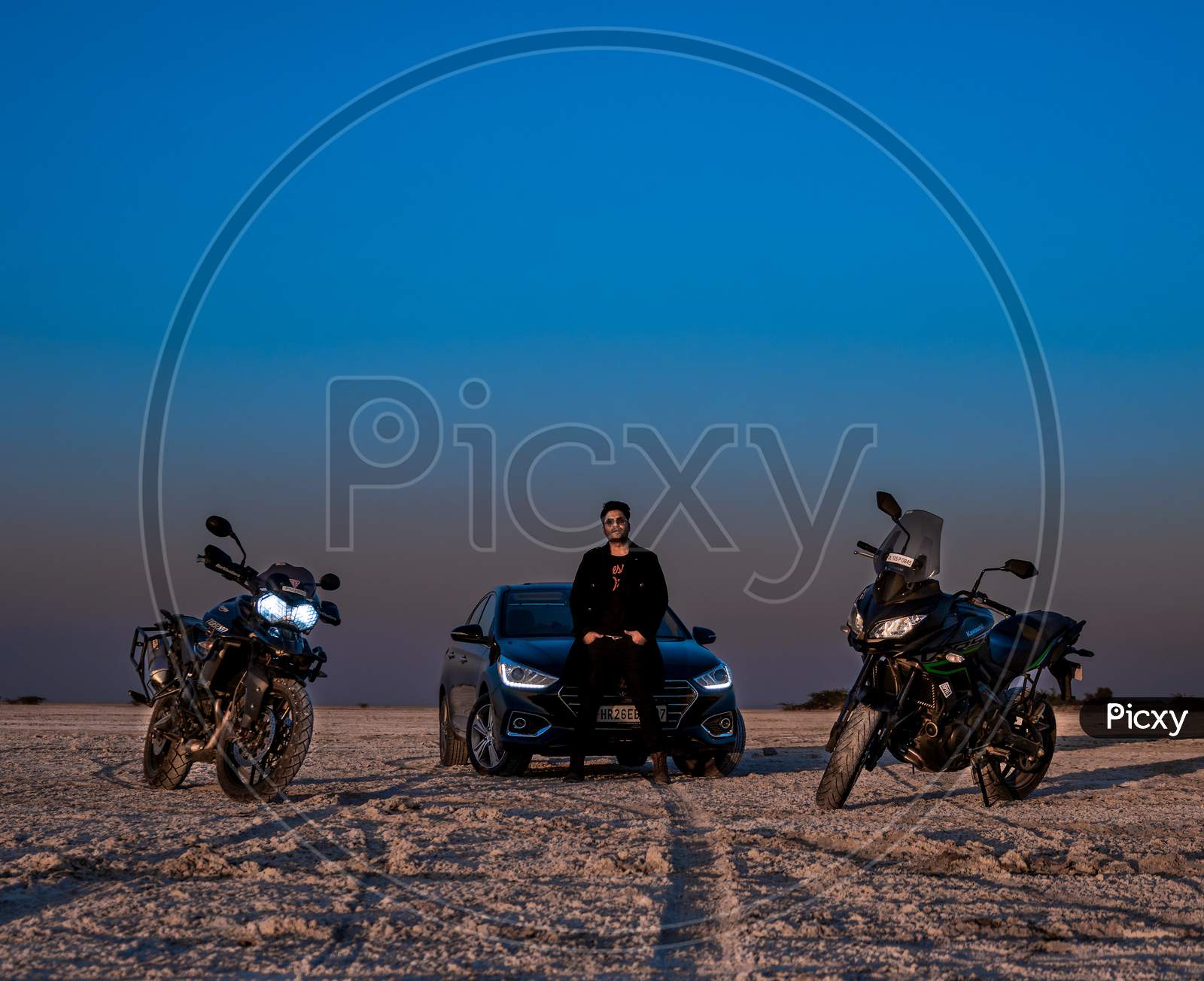 model with cars and bike posing in the desert