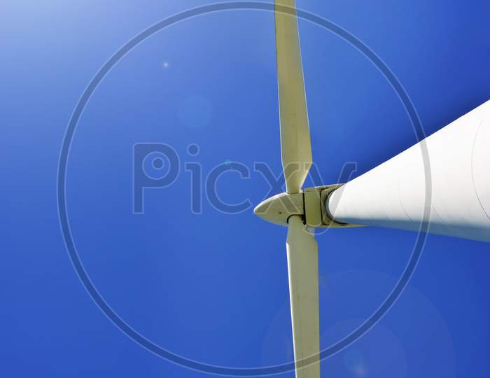 White Wind power storage turbine against blue sky