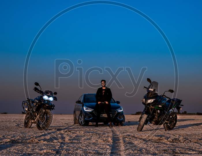 model with cars and bike posing in the desert