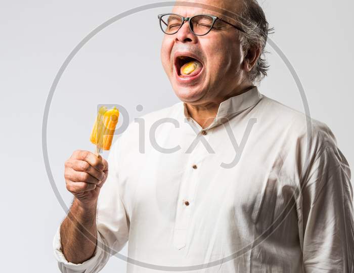 Retired Indian Old Man Eating Ice Cream, Standing Icolated Against White Background