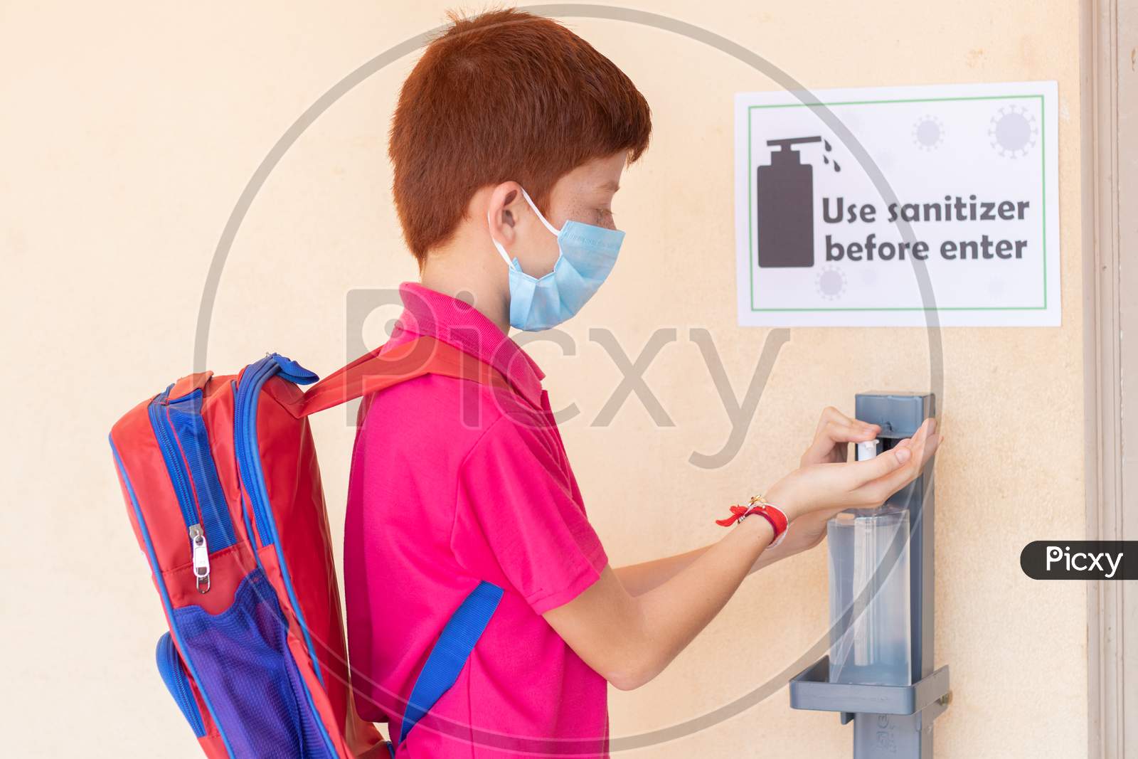 Kid With Medical Mask Using Hand Sanitizer Before Entering Classroom - Concept Of Back To School Or School Reopen And Coronavirus Or Covid-19 Safety Measures.