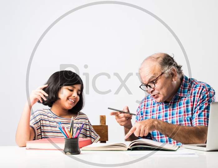 Indian Asian Grandfather Is Teaching His Granddaughter Or Grandaughter At Home